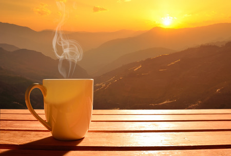 32283969 - morning cup of coffee with mountain background at sunrise